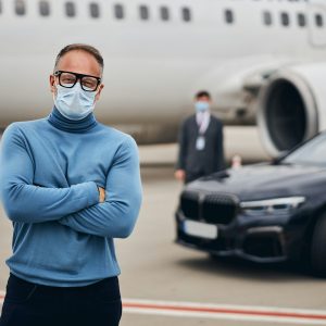 Passenger in a face mask and eyeglasses staring ahead