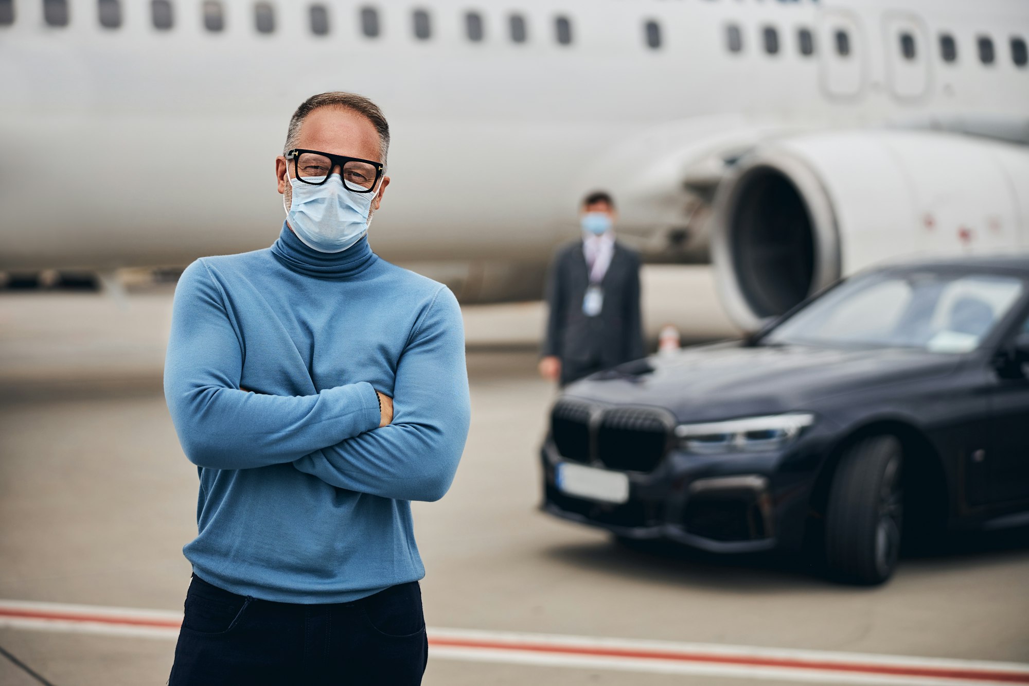 Passenger in a face mask and eyeglasses staring ahead