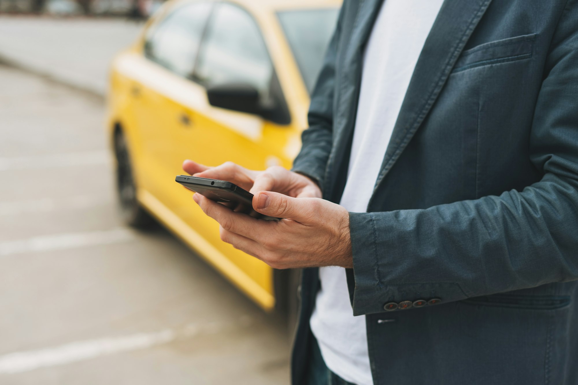 The man calls a taxi by app on his phone at street